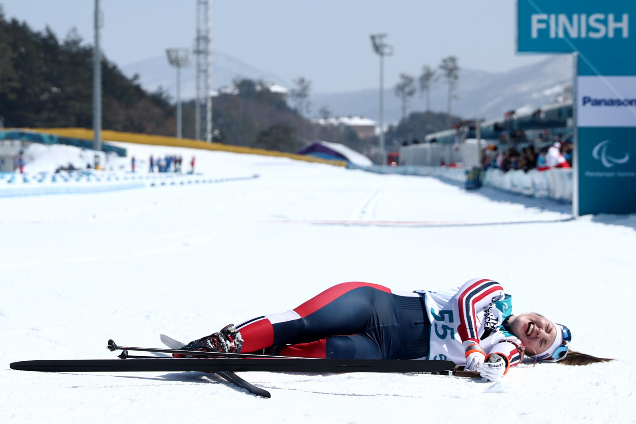 Vilde Nilsen collapses after crossing the finish line in the women's 6km standing biathlon event at the Alpensia Biathlon Centre ©Getty Images
