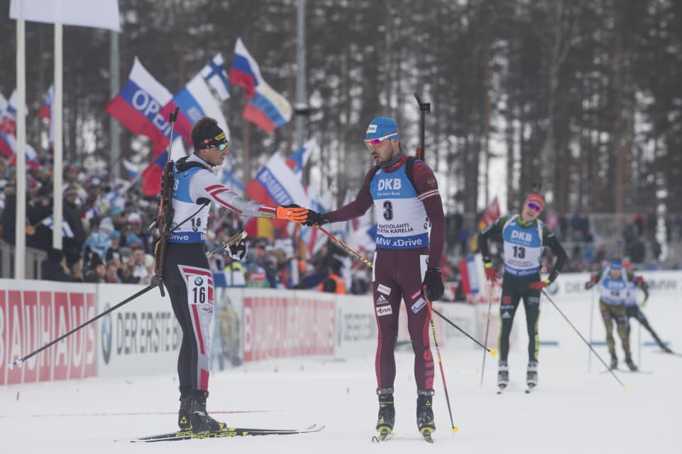 Austrlia's Julian Eberhard, left, winner of the IBU World Cup mass start race in Kontiolahti, apologises to Anton Shipulin for the accident in the final approaches that caused the Russian to fall ©IBU
