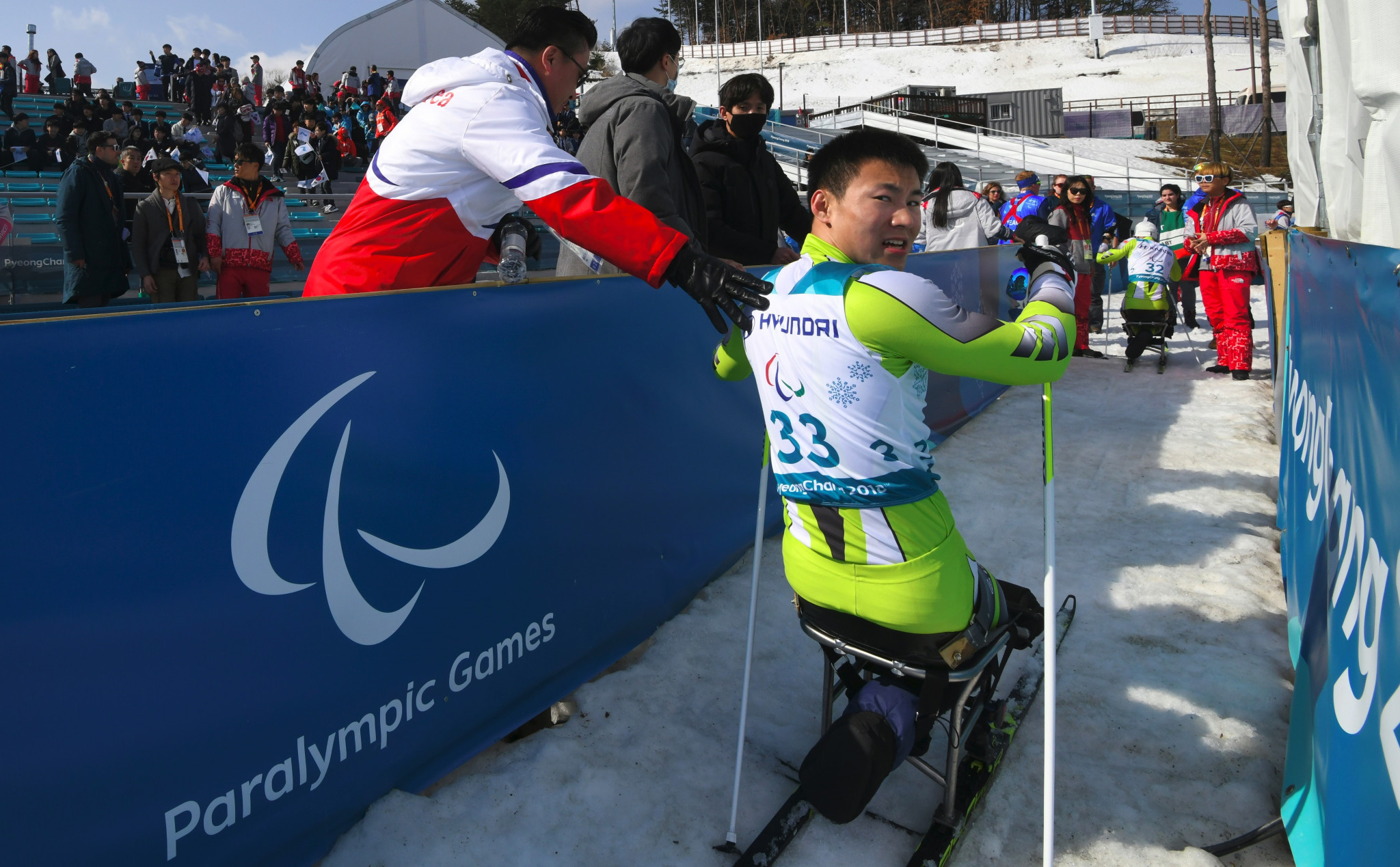 North Korea's Kim Jong Hyon is greeted by a national delegate after competing in the men's 1.1km sitting cross-country skiing event ©Getty Images