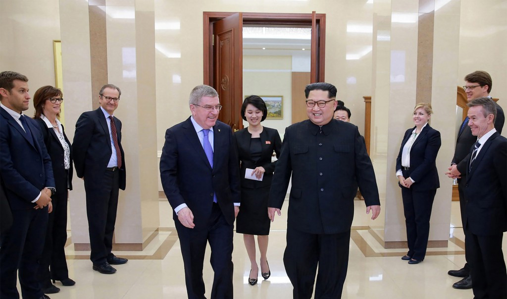 Thomas Bach speaks with Kim Jong-un surrounded by members of the IOC delegation ©AFP/Getty Images