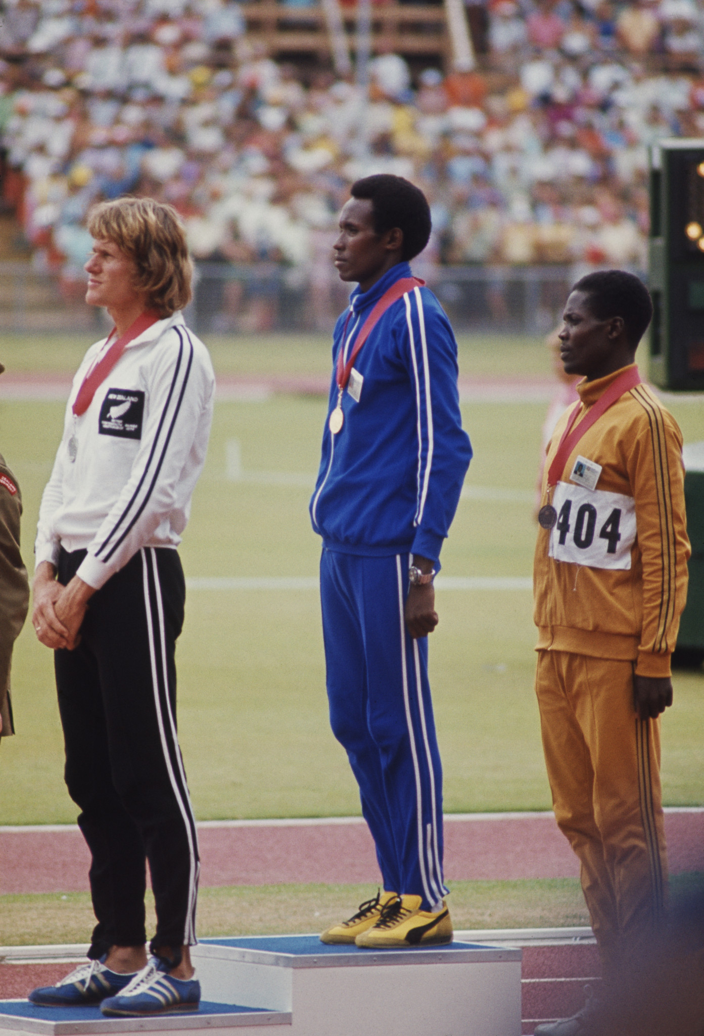 Filbert Bayi, centre, listens to Tanzania's national anthem after winning the Commonwealth Games gold medal in the 1,500m at Christchurch 1974 and beating New Zealand's John Walker, left, in a legendary race ©Getty Images