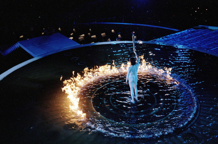 Cathy Freeman lifts the Torch aloft at Sydney 2000 after setting light to the ring of fire that - eventually after a long delay - moved up to become part of the Olympic Cauldron ©Getty Images