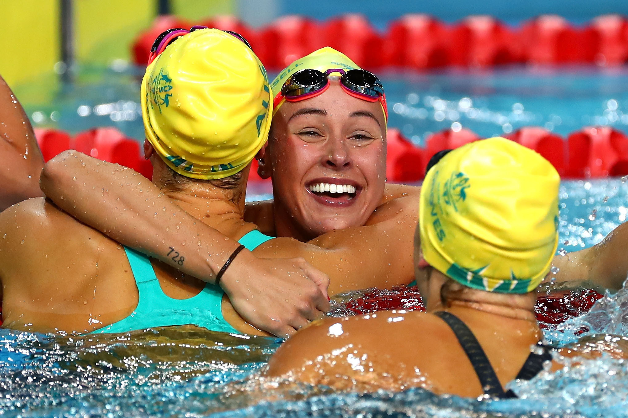 Emma McKeon celebrates in between her two team-mates after the Australian clean sweep ©Getty Images