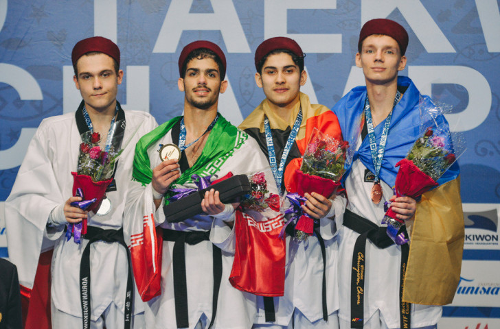 Ali Eshkevarian, second left, displays Iran's sixth gold of the World Taekwondo Junior Championships in Hammamet after the men's under-73kg final ©World Taekwondo