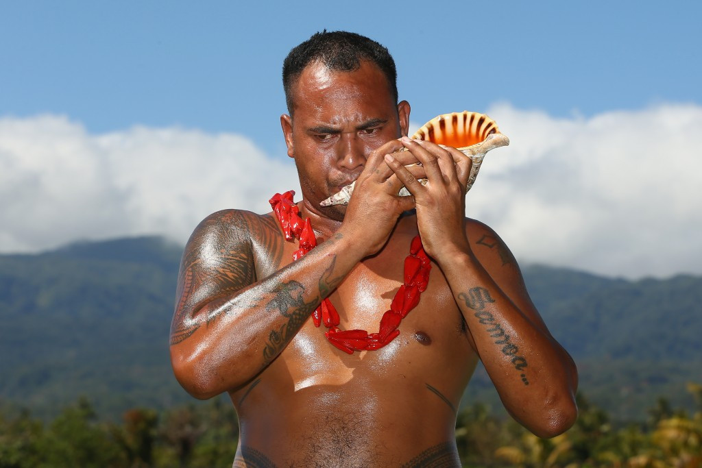 A conch player provides the welcome music before athletes at Samoa 2015 receive their medals ©Getty Images