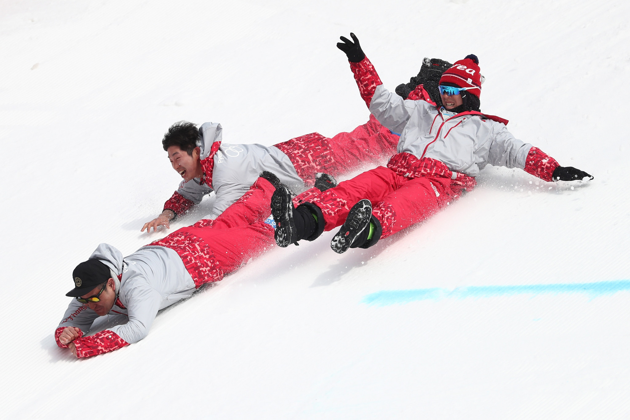 Olympic volunteers slide down a ski slope at Pyeongchang 2018  ©Getty Images