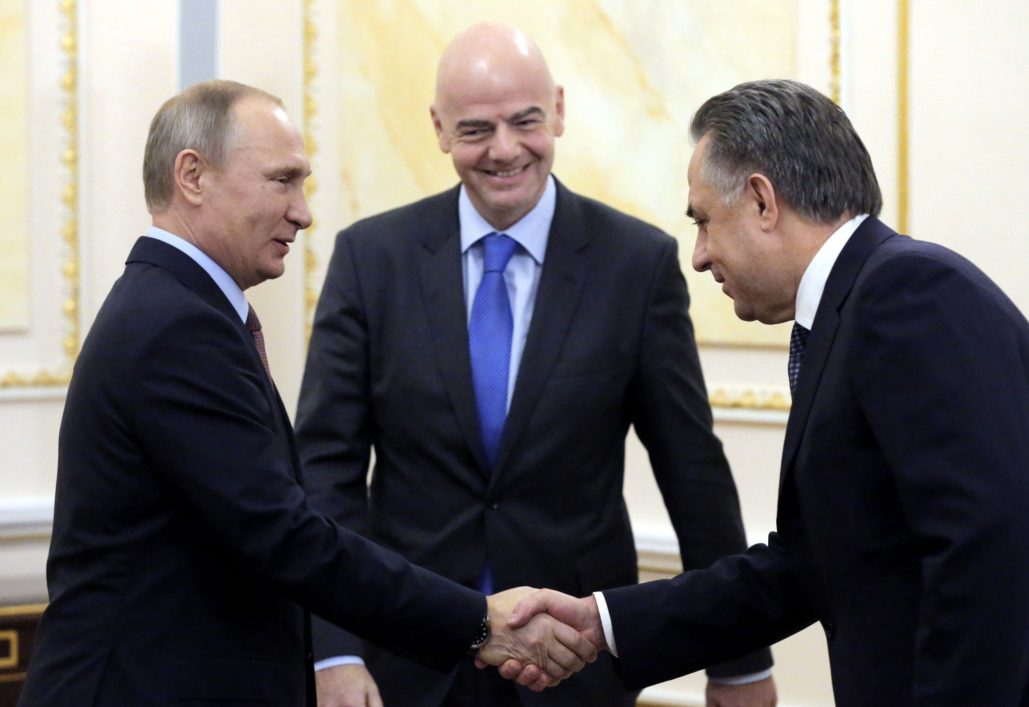 Vladimir Putin, left, and Vitaly Mutko, right, either side of FIFA President Gianni Infantino ©Getty Images