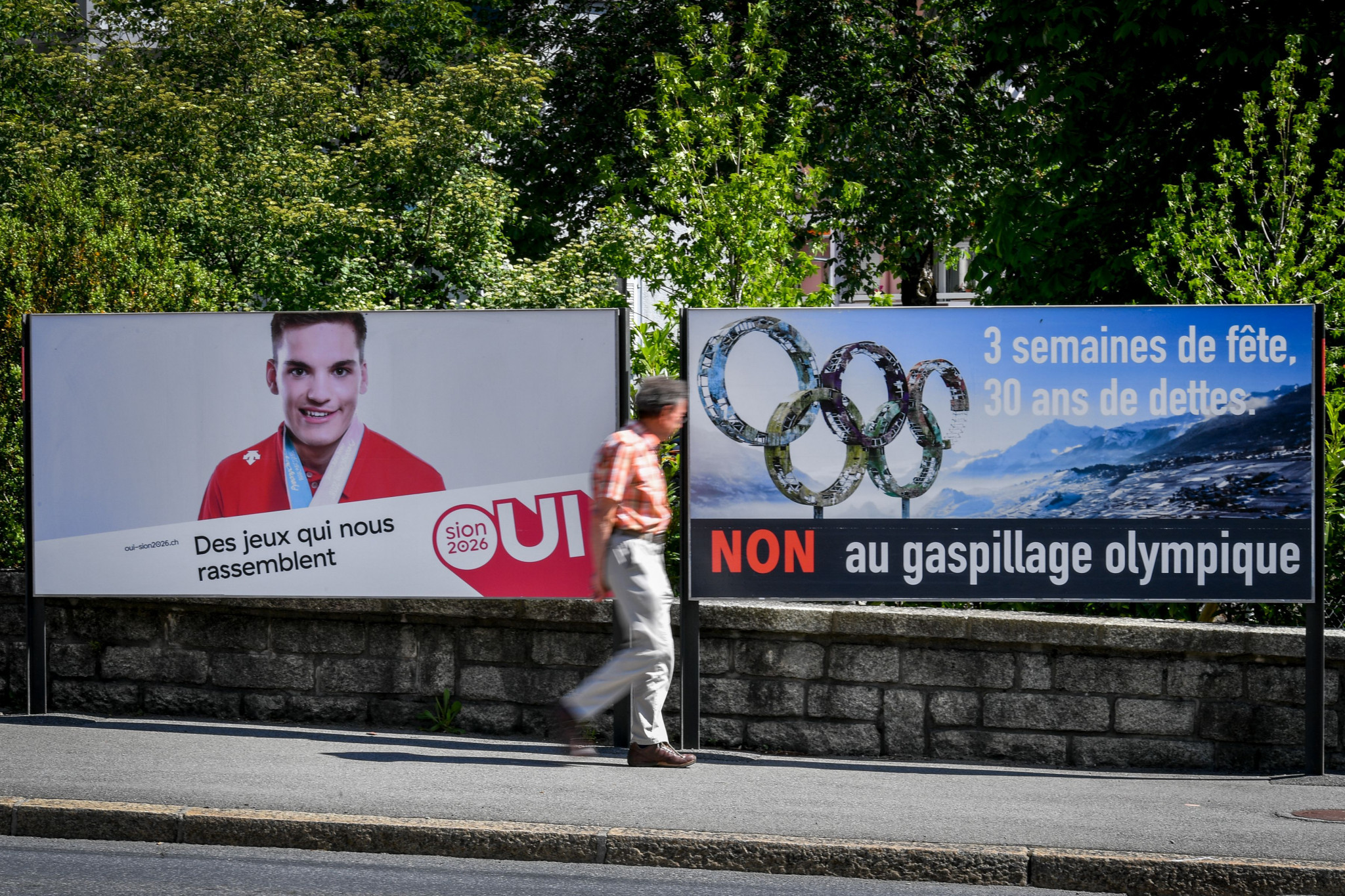 Posters supporting and opposing the Sion 2026 bid placed side by side ©Getty Images