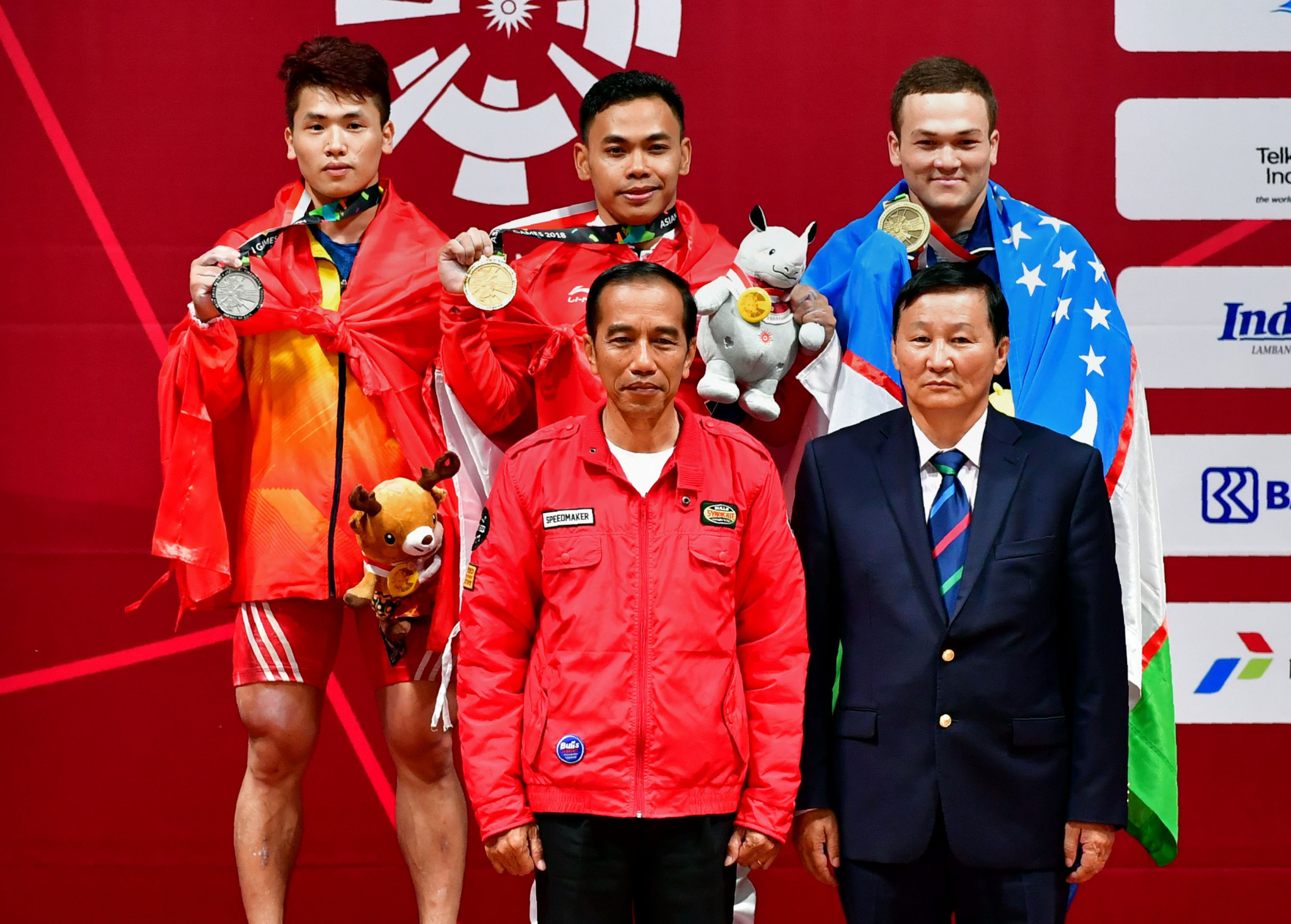 Indonesia President Joko Widodo, front left, was among the spectators as home favourite Eko Yuli Irawan, back centre, won the men’s 62 kilograms weightlifting event here at the 2018 Asian Games today ©Getty Images