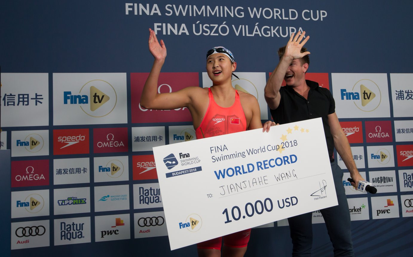 China's Jianjiahe Wang receives a prize cheque for breaking the world record in the 400m freestyle at the FINA Swimming World Cup ©FINA