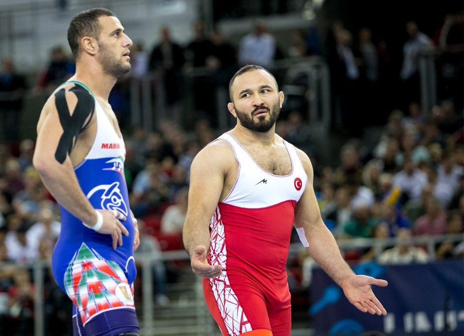 Iran's Mahdi Aliyarifeizabadi, left, won Greco-Roman bronze at 97kg when his opponent, not pictured, chose not to compete ©UWW