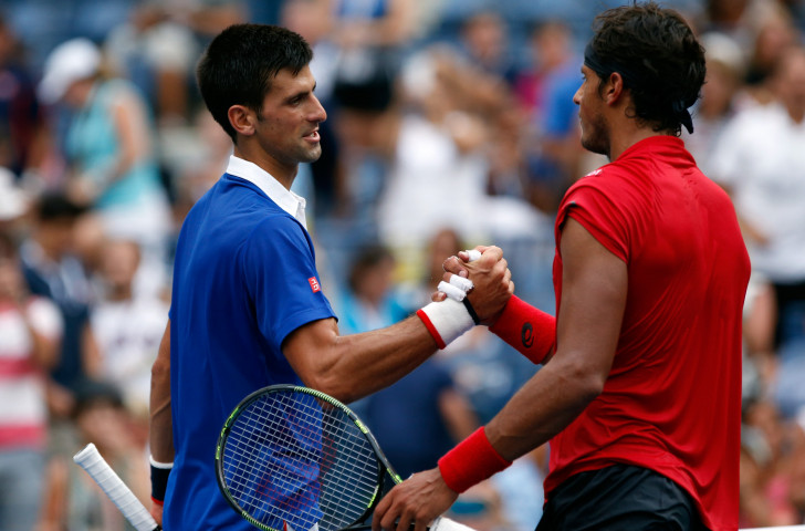 Brazil's Joao Souza, right, shakes hands with Novak Djokovic after being beaten in the first round of the 2015 US Open tournament ©Getty Images