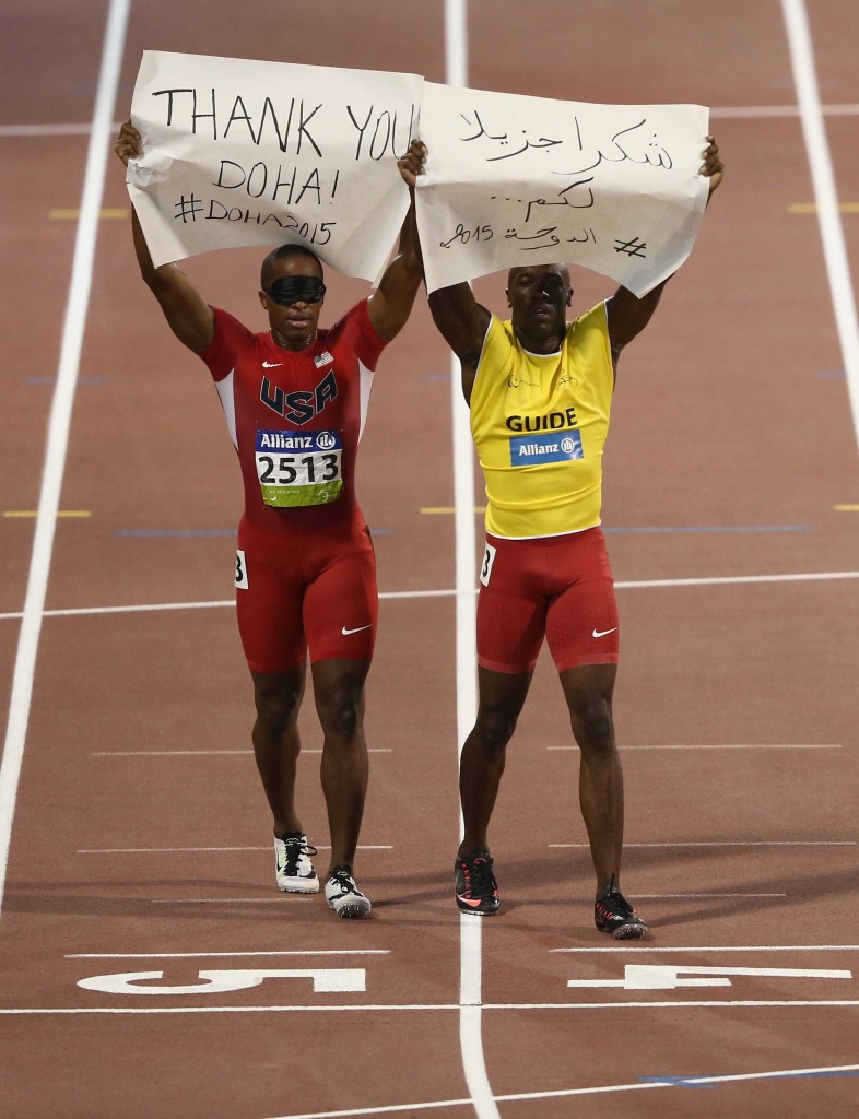The United States' David Brown held up a banner thanking Doha after winning the men's 100m T11 final