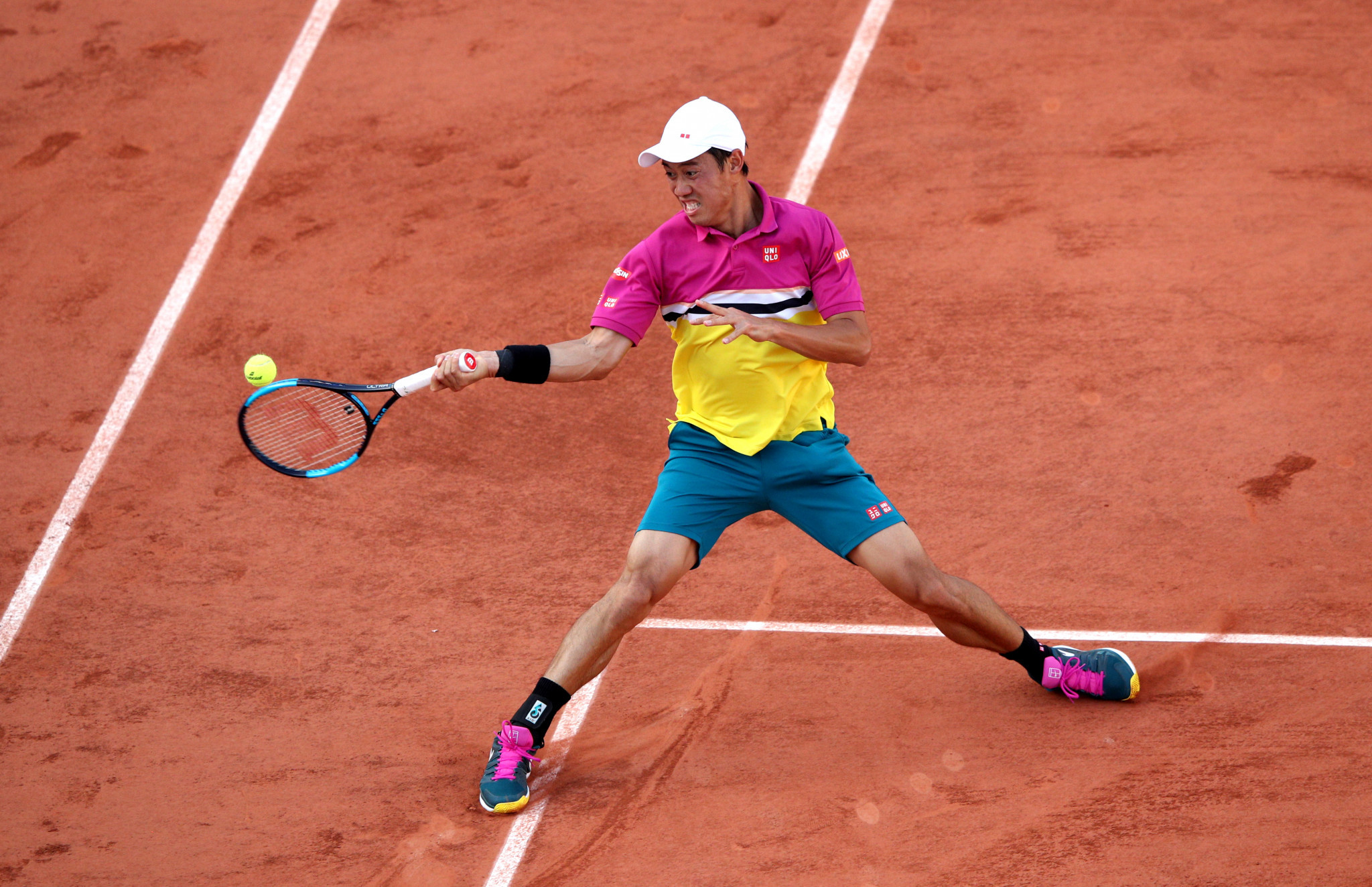 Kei Nishikori of Japan slides along the clay to play a forehand against French favourite Benoit Paire ©Getty Images