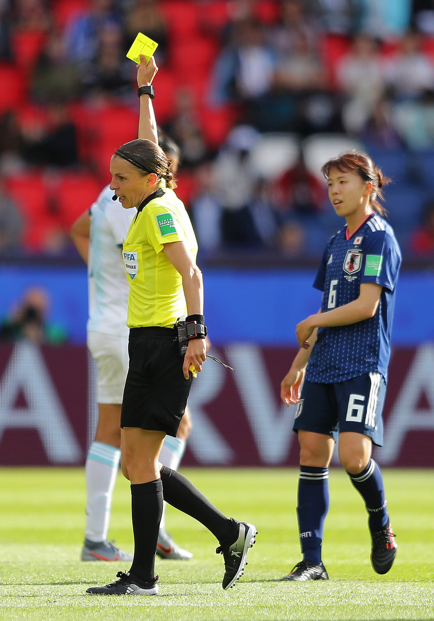 French referee Stephanie Frappart shows Hina Sugita of Japan a yellow card ©Getty Images