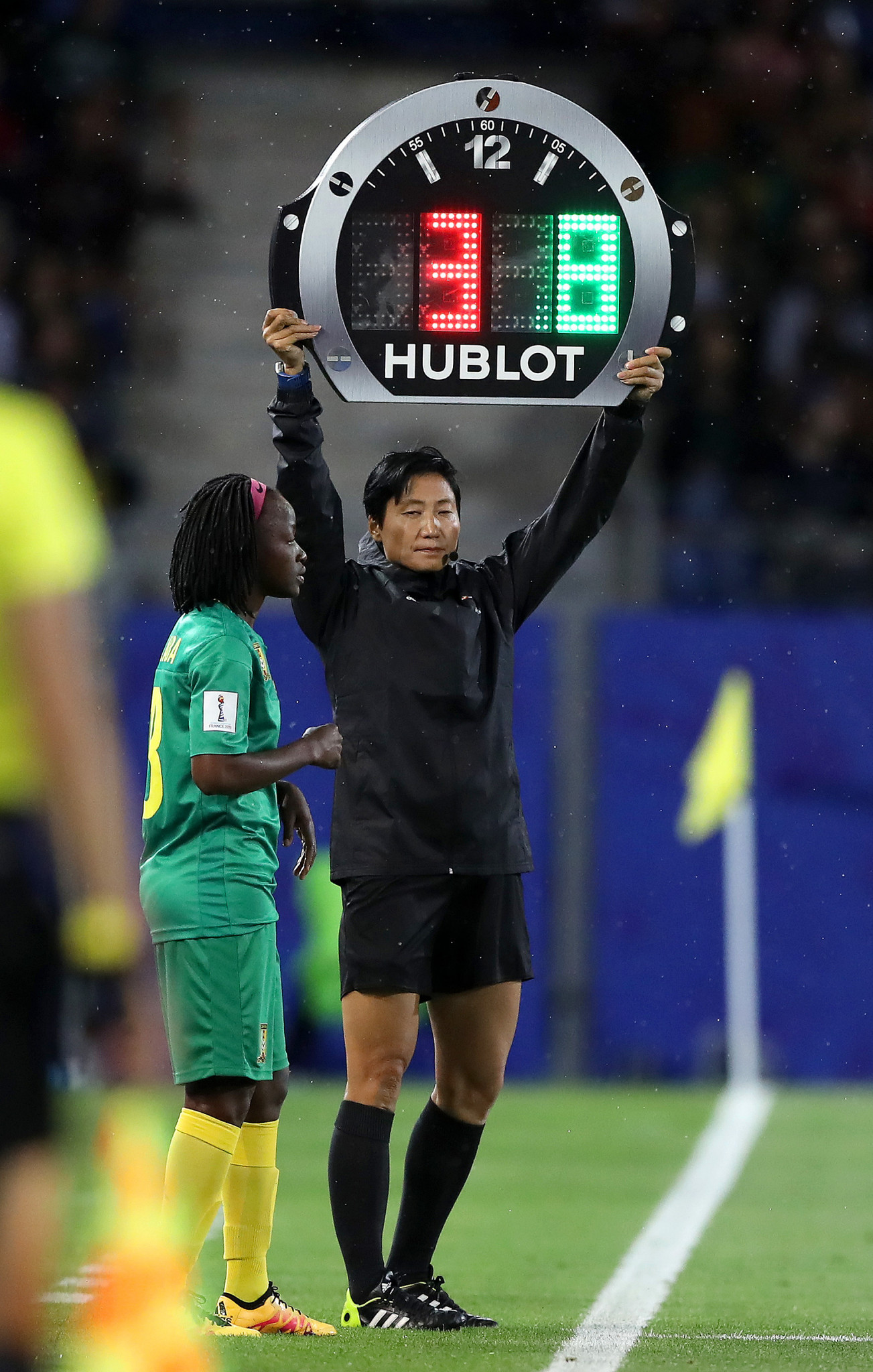 Fourth Official Liang Qin uses the electronic board to indicate a substitution as Cameroon sought a way back into the match ©Getty Images 