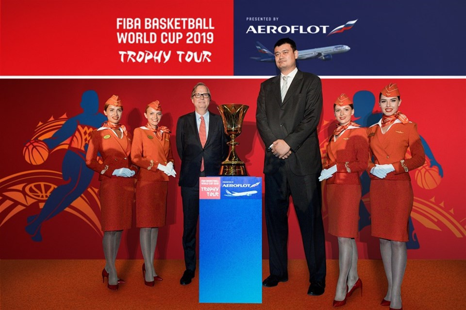 Yao Ming, an ambassador of the 2019 FIBA World Cup, and Frank Leenders, director general of FIBA media and marketing services, with Aeroflot stewardesses at the launch of the Trophy Tour in Beijing in May ©FIBA