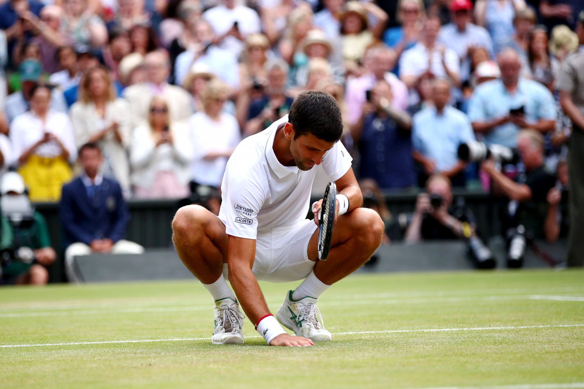 Djokovic celebrated his victory in unusual fashion – by chewing on some of the Wimbledon turf ©Getty Images