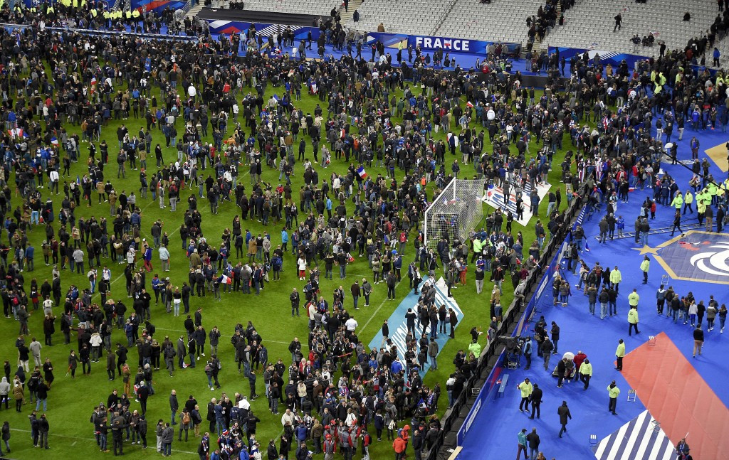 French and Germany fans spill onto the pitch followng explosions at the Stade de France which killed three people as Paris was hit by its worst attack since the end of World War Two 