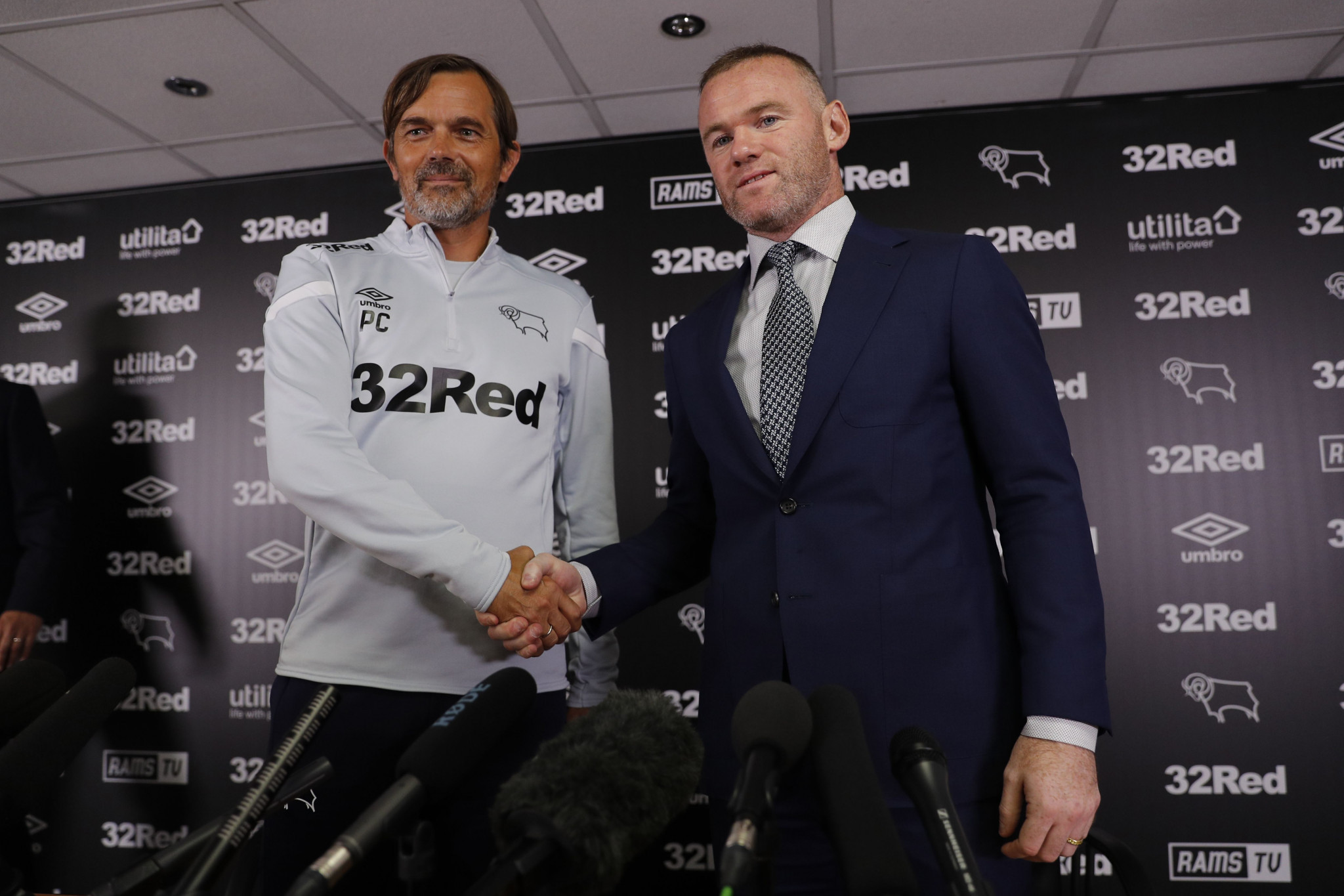 Phillip Cocu, left, shakes hands with new signing Wayne Rooney, who will controversially wear number 32 ©Getty Images