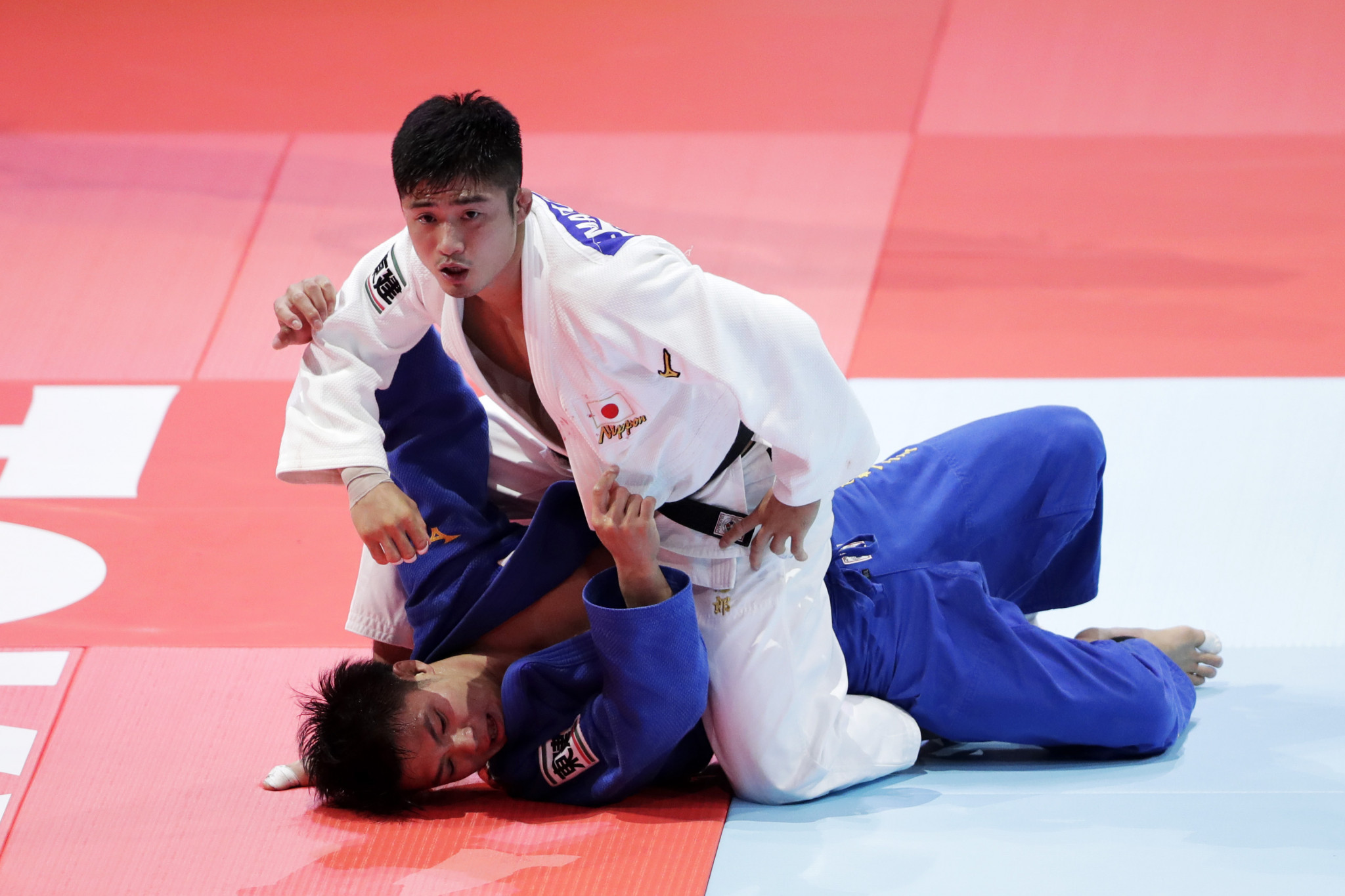 Abe's brother, Hifumi, in blue, lost his world crown in the men's under-66kg competition ©Getty Images