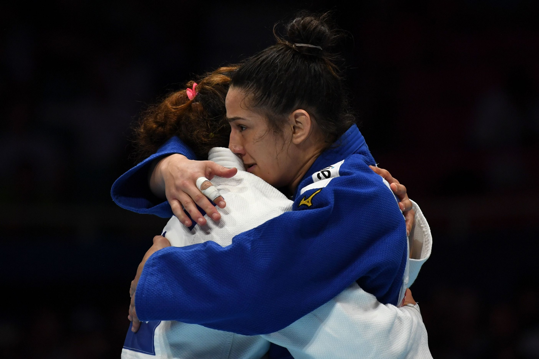 Mayra Aguiar of Brazil, in blue, hugs Patricia Sampaio of Portugal after winning bronze ©Getty Images