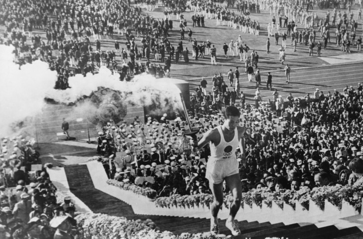 Olympic flame Torchbearer Yoshinori Sakai mounts the steps to light the cauldron at the Opening Ceremony of the 1964 Summer Olympic Games at Tokyo's National Olympic Stadium ©Getty Images