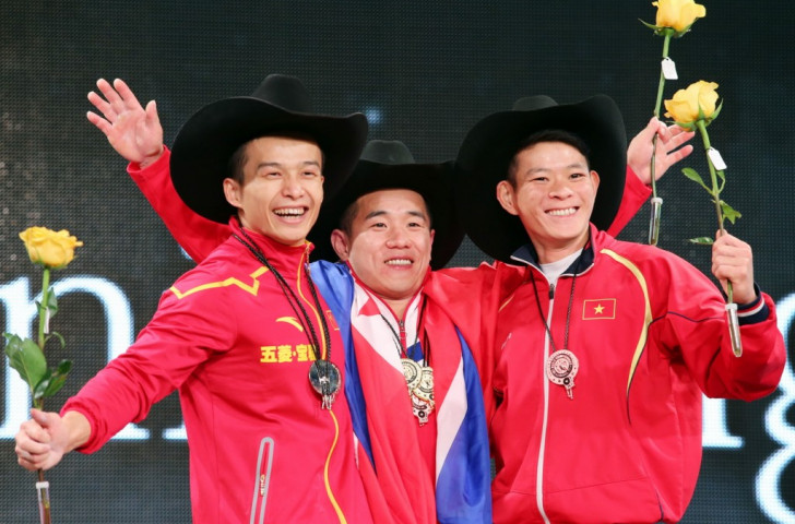 The men's 56kg overall medallists hold aloft yellow roses, paying homage to the famous American folk song, 