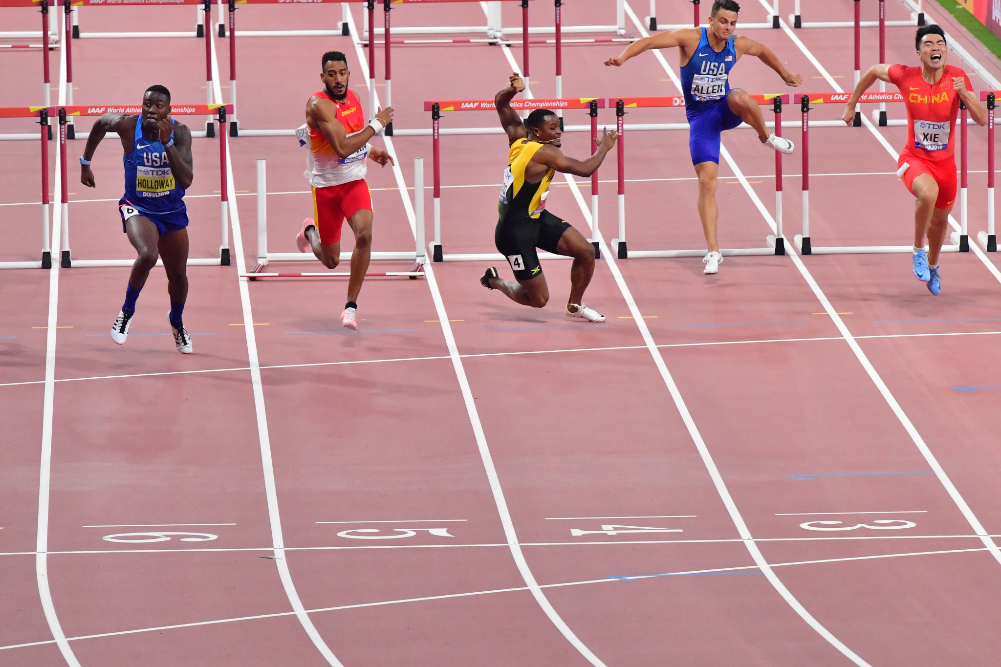 Jamaica's Omar Mcleod falls as America's Grant Holloway runs past Spain's Orlando Ortega to win the men's 110m hurdles final ©Getty Images