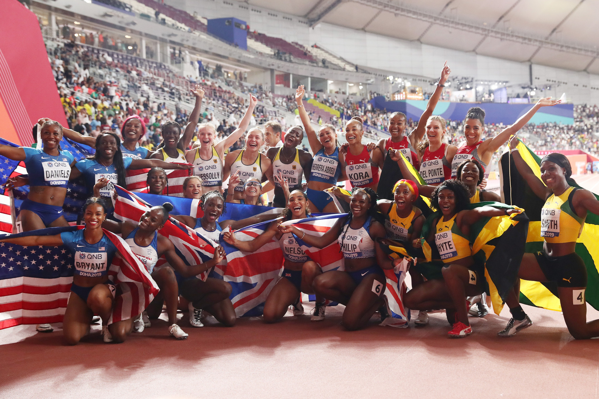 The women's 4x100m relay teams pose together at the end of their race ©Getty Images