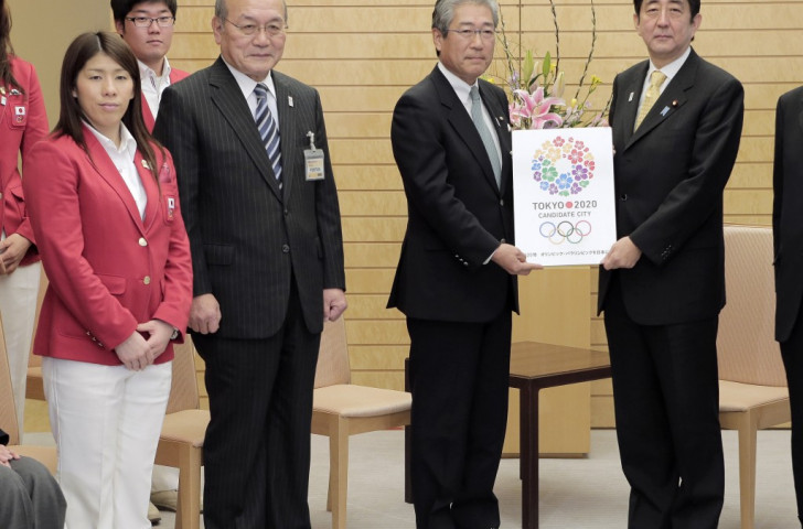 The easy bit. Japanese Prime Minister Shinzō Abe (right) and Japanese Olympic Committee President Tsunekazu Takeda (second right) pictured in 2013 showing off the Tokyo 2020 logo used during the bid process. The new version for the Games themselves has hit problems ©Getty Images