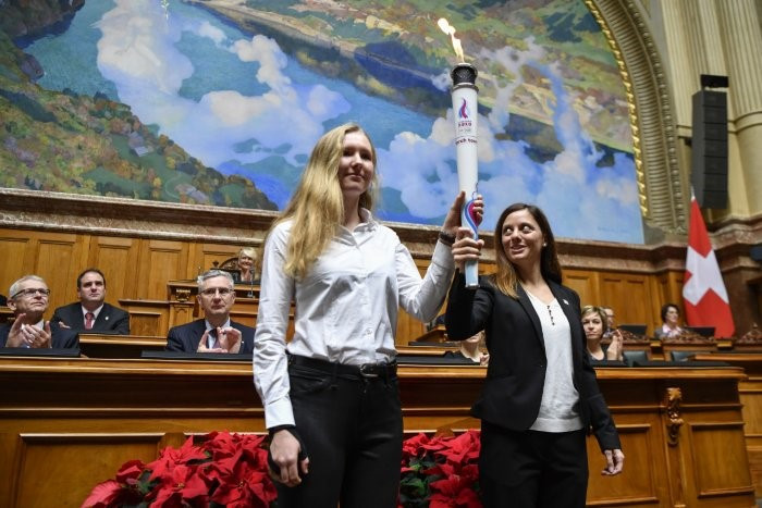 Virginie Faivre and Caroline Ulrich carry the Youth Olympic flame at the National Council ©Lausanne 2020