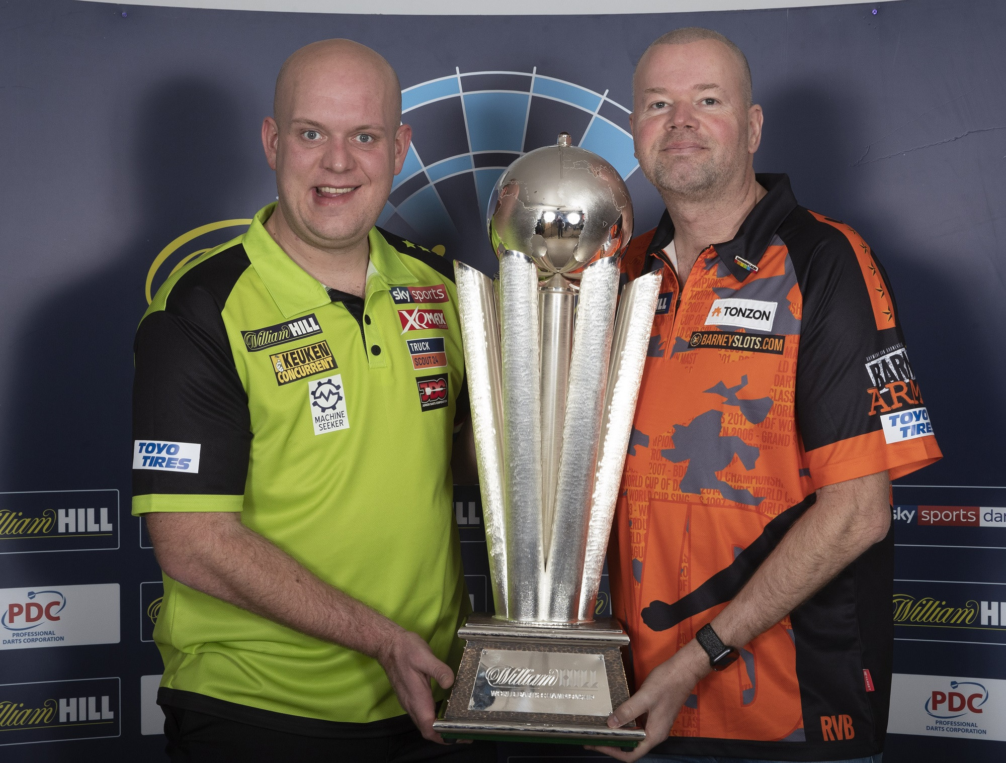 Current PDC World Champion Michael Van Gerwen, left, pictured with the trophy that he will defend at the Championships that start on Friday alongside fellow Dutchman and past winner Raymond Van Barneveld, whose last Championship this will be ©PDC