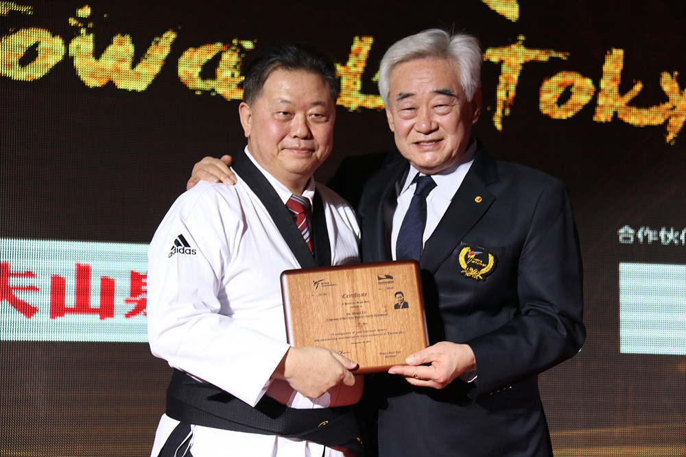 Dr. Lu Dezhi, left, received his black belt certificate from Chungwon Choue ©Getty Images