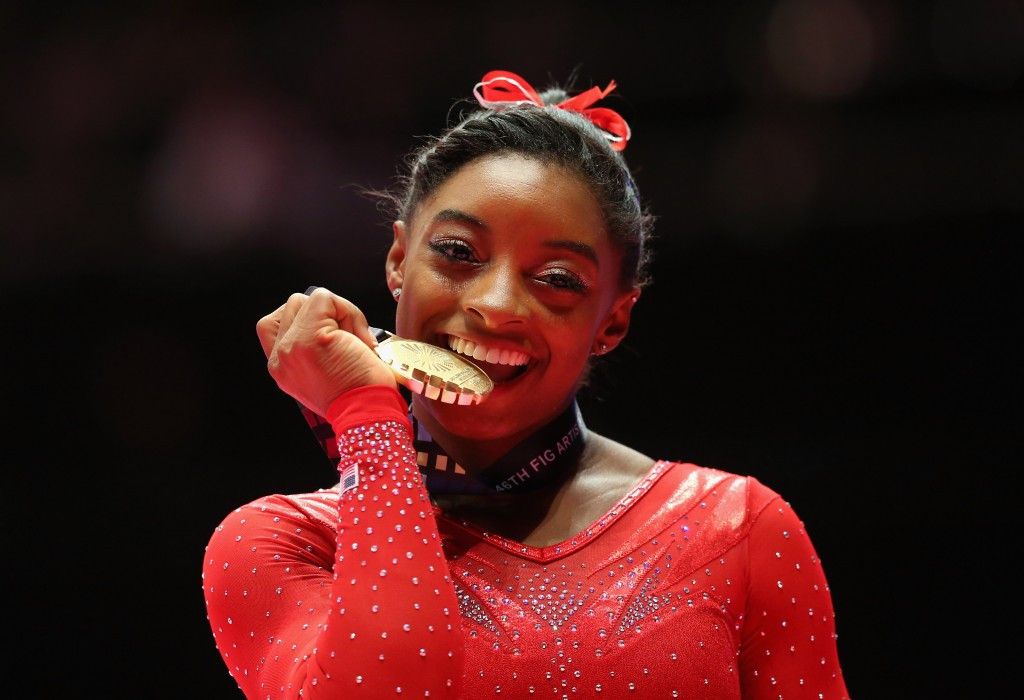 American Simone Biles made history by claiming a third straight women's all-around title at Glasgow 2015