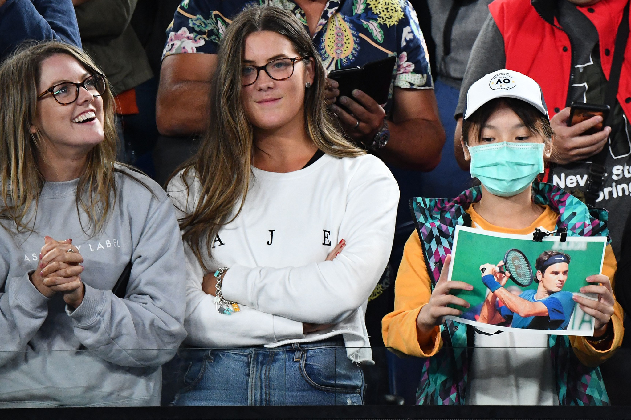 A fan in a face mask holds a picture of Federer during his victory ©Getty Images