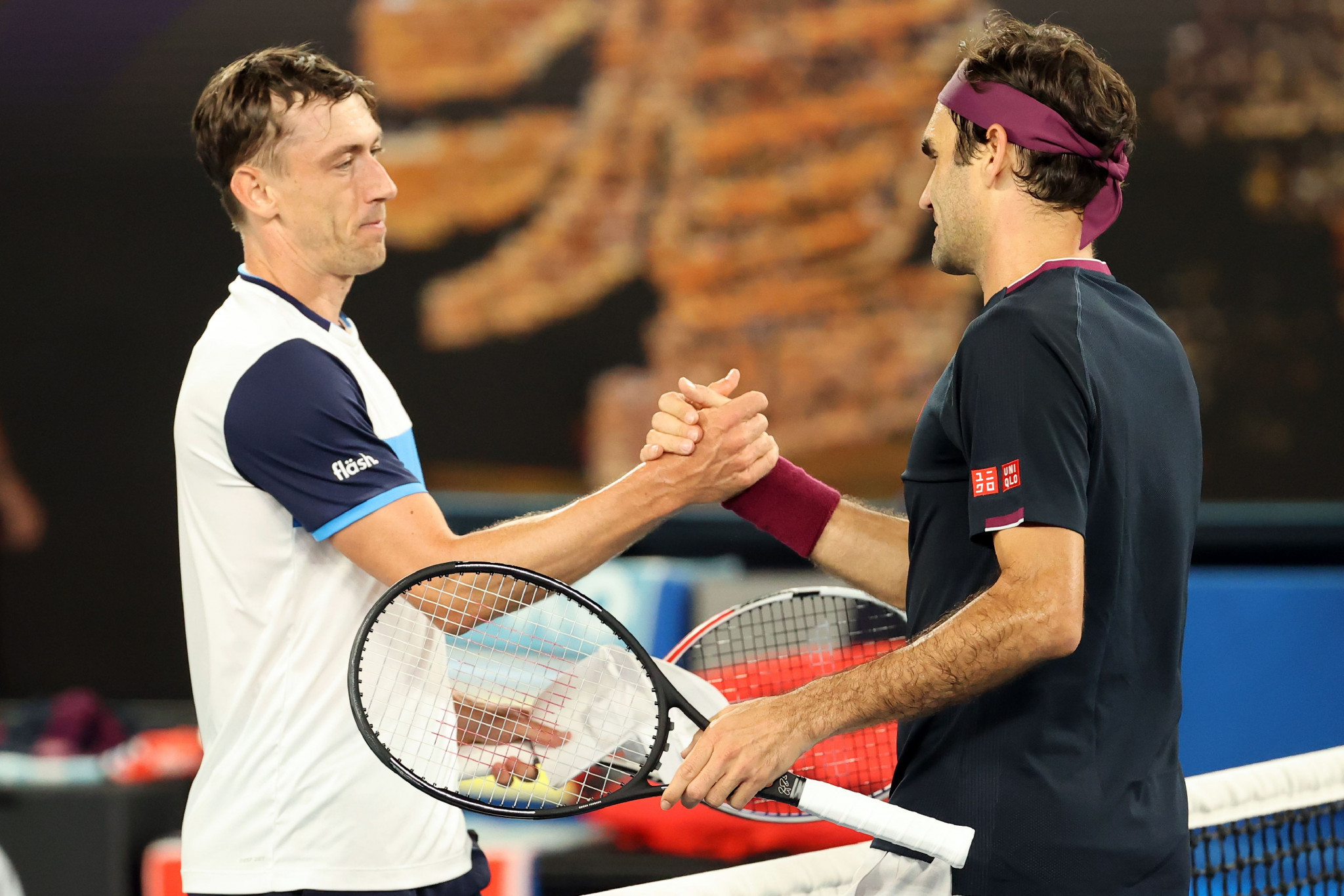 Australia's John Millman, left, shakes hands with Roger Federer after losing his Australian Open third round match on a tie-breaker in Melbourne - after which allegations were made that he had been attempting to tamper with the balls before he served them ©Getty Images