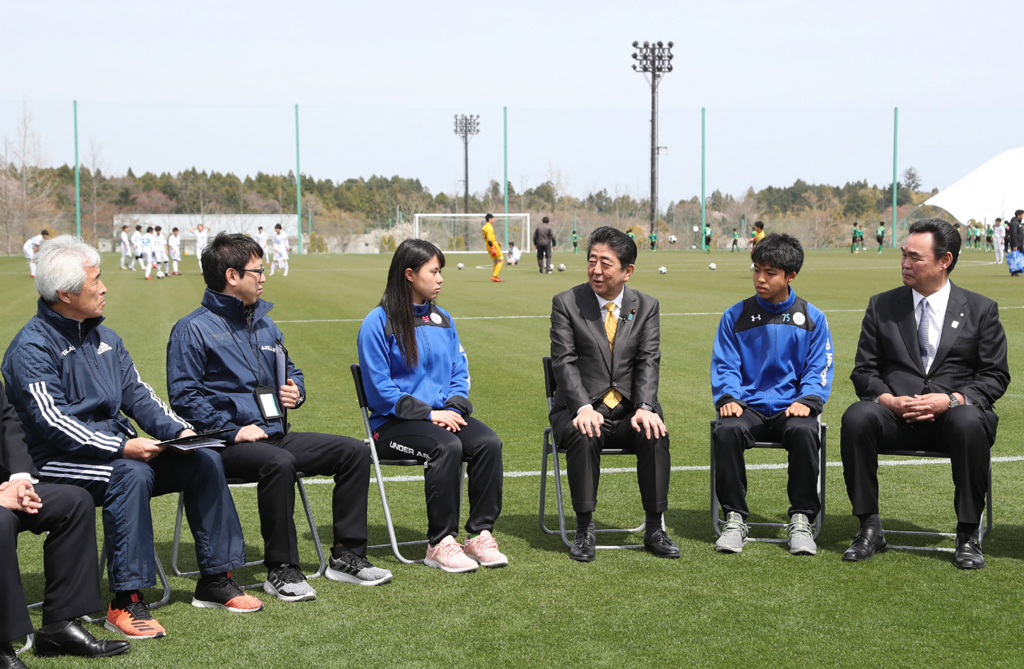Japanese Prime Minister Shinzo Abe, third right, speaks to local schoolchildren at the re-opened J-Village ©Getty Images