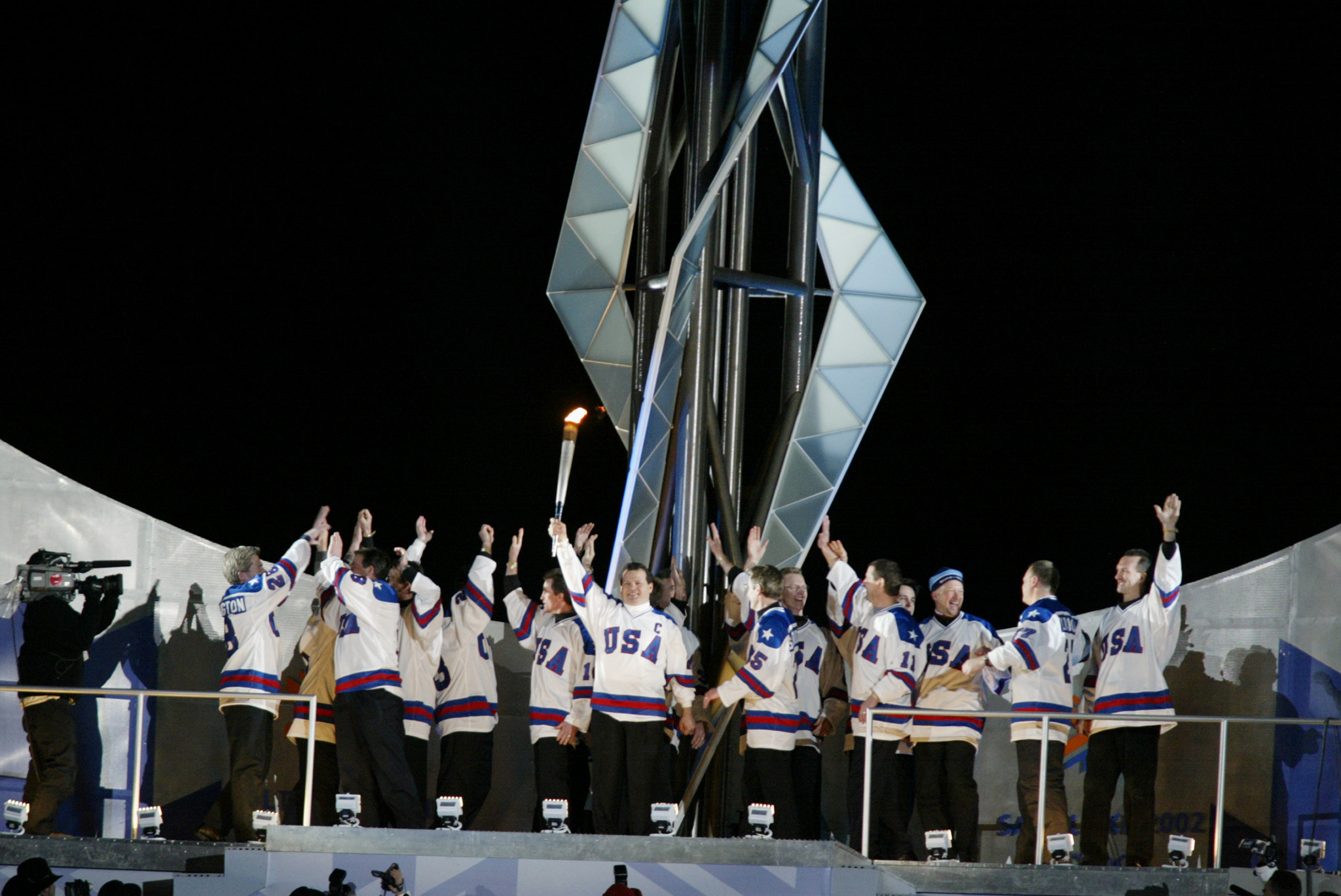 The US team which won the ice hockey title at the Lake Placid 1980 Olympics lights the Cauldron at the Opening Ceremony of the Salt Lake City 2002 Winter Games ©Getty Images