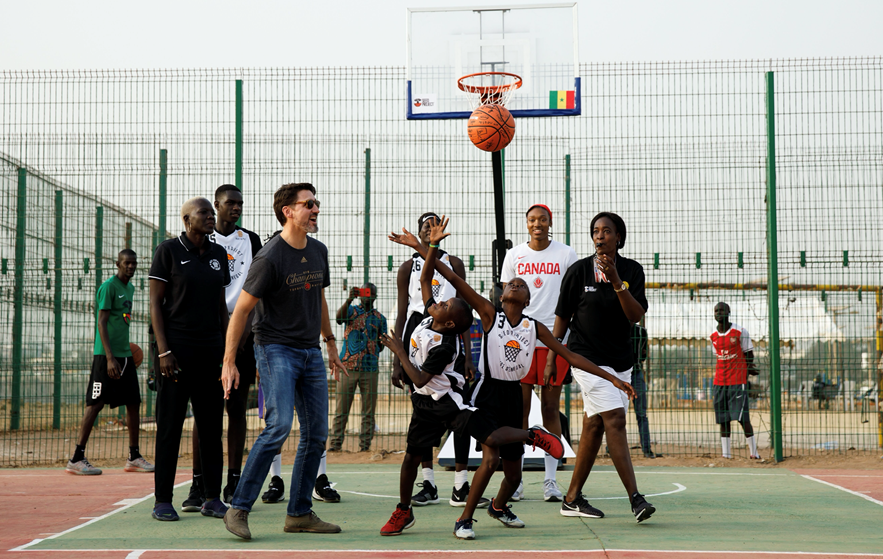 Canadian Prime Minister Justin Trudeau tossing the ball up between two young Senegalese athletes from under the watchful eye of Kayla Alexander, who qualified as one of the players to represent Canada at Tokyo 2020 ©COC