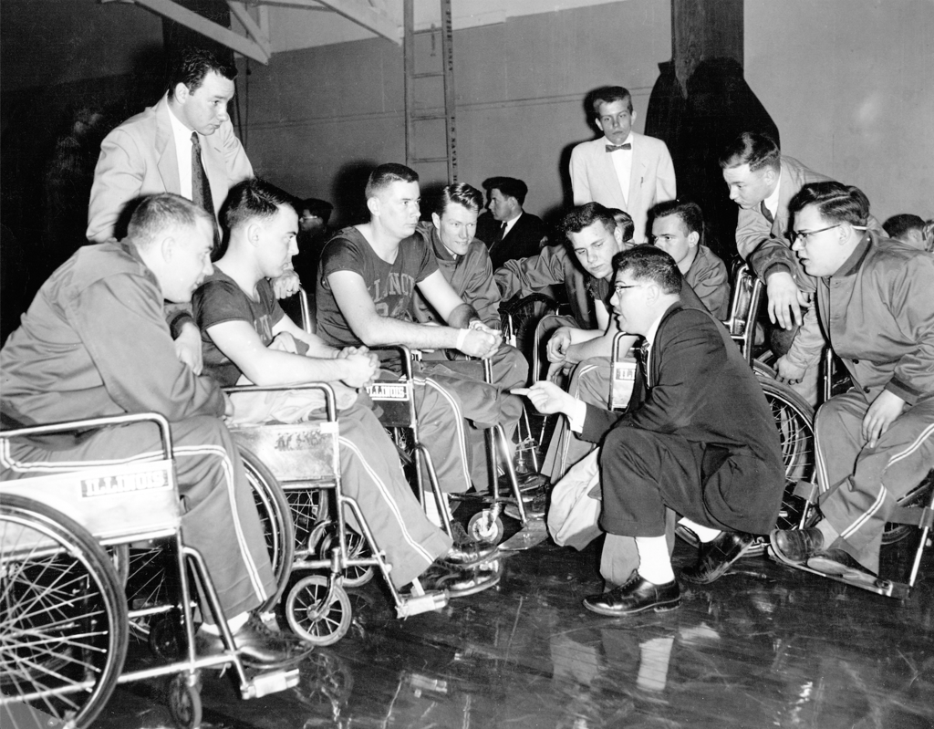 Dr. Tim Nugent kneels as he coaches a team in 1955 ©Brian Stauffer/University of Illinois