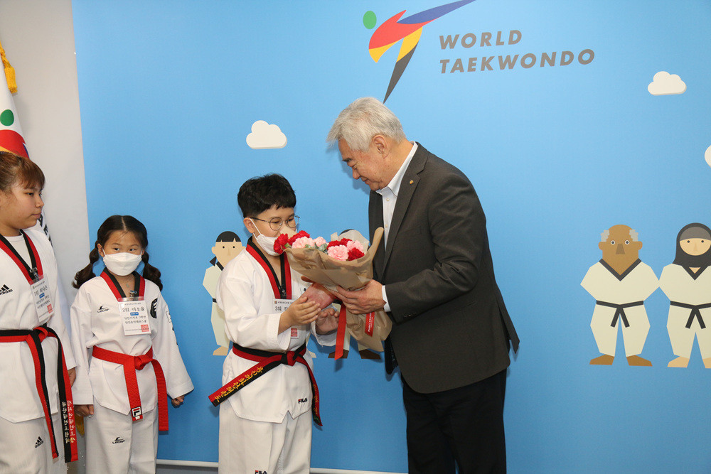 Chungwon Choue presents the children, who finished in the top three in a national taekwondo quiz, with gifts, as they visit World Taekwondo's headquarters in Seoul ©World Taekwondo