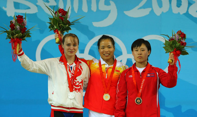 Silver medallist Marina Shainova of Russia, Gold medalist Chen Yanqing of China and Bronze medalist O Jong Ae of North Korea pose on the podium during the medal ceremony for the Women's 58kg group A weightlifting event at the Beijing University of Aeronautics & Astronautics Gymnasium on Day 3 of the Beijing 2008 Olympic Games on August 11, 2008 in Beijing, China. © Stu Forster/Getty Images.