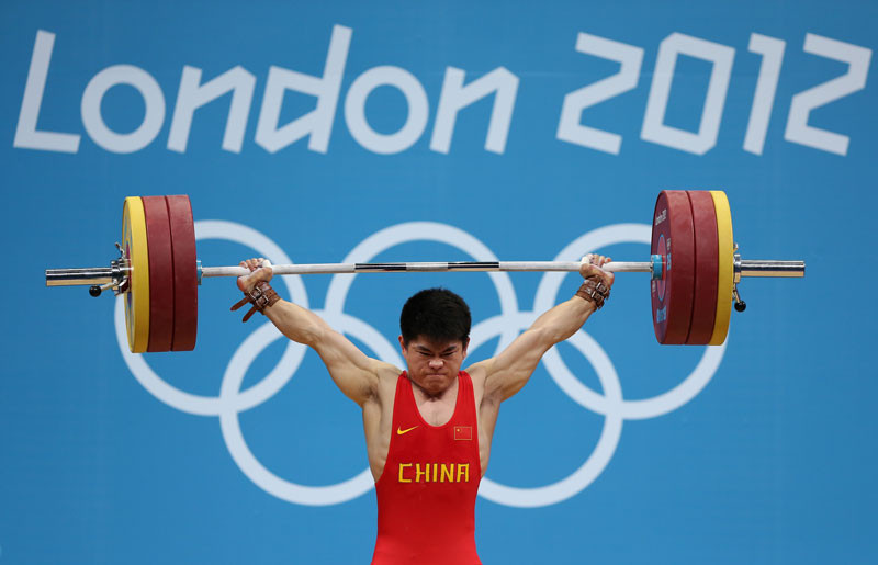 Qingfeng Lin of China competes during the Men's 69kg Weightlifting Final on Day 4 of the London 2012 Olympic Games at ExCeL on July 31, 2012 in London, England. © Quinn Rooney/Getty Images.
