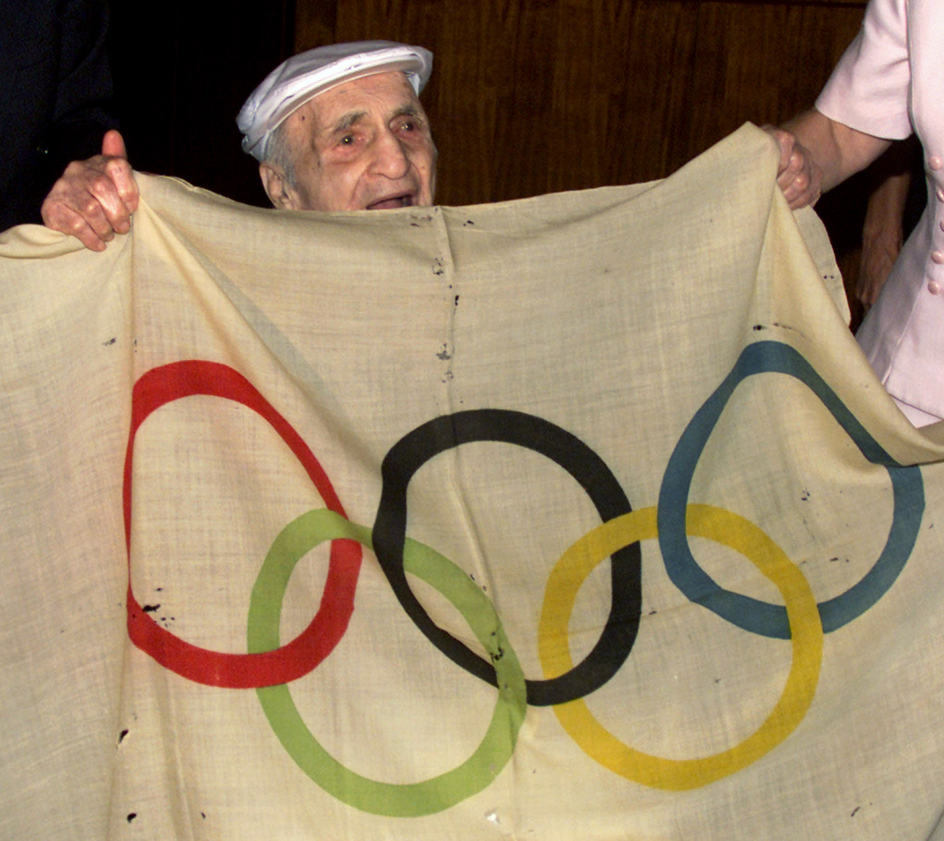 Hal Prieste, then 103, holds the original Olympic flag that he stole from a pole during the 1920 Olympics in Antwerp, where he won a bronze medal in diving. He handed it back to IOC President Juan Antonio Samaranch during the IOC Session in Sydney in 2000 ©Getty Images