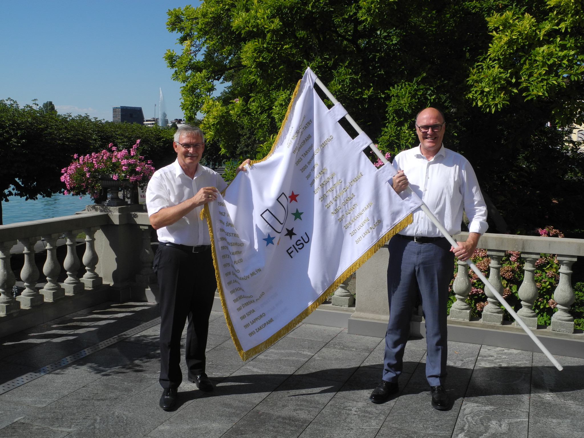 The two Cantonal Councillors Barraud Andreas (Schwyz) and Martin Pfister (Zug) with the FISU flag ©Lucerne 2021