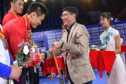 Zhou Jinqiang, President of the Chinese Weightlifting Association, presents the gold medal to Lu Xiaojun ©CWA