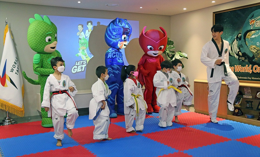 Three-time world champion Lee Dae-hoon teaches children some taekwondo moves ©World Taekwondo