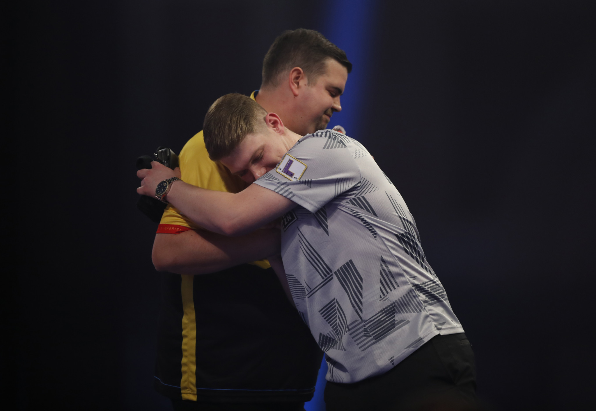Nico Kurz (grey shirt) embraces compatriot Michael Clemens following the all German match-up at the PDC World Darts Championship ©Getty Images