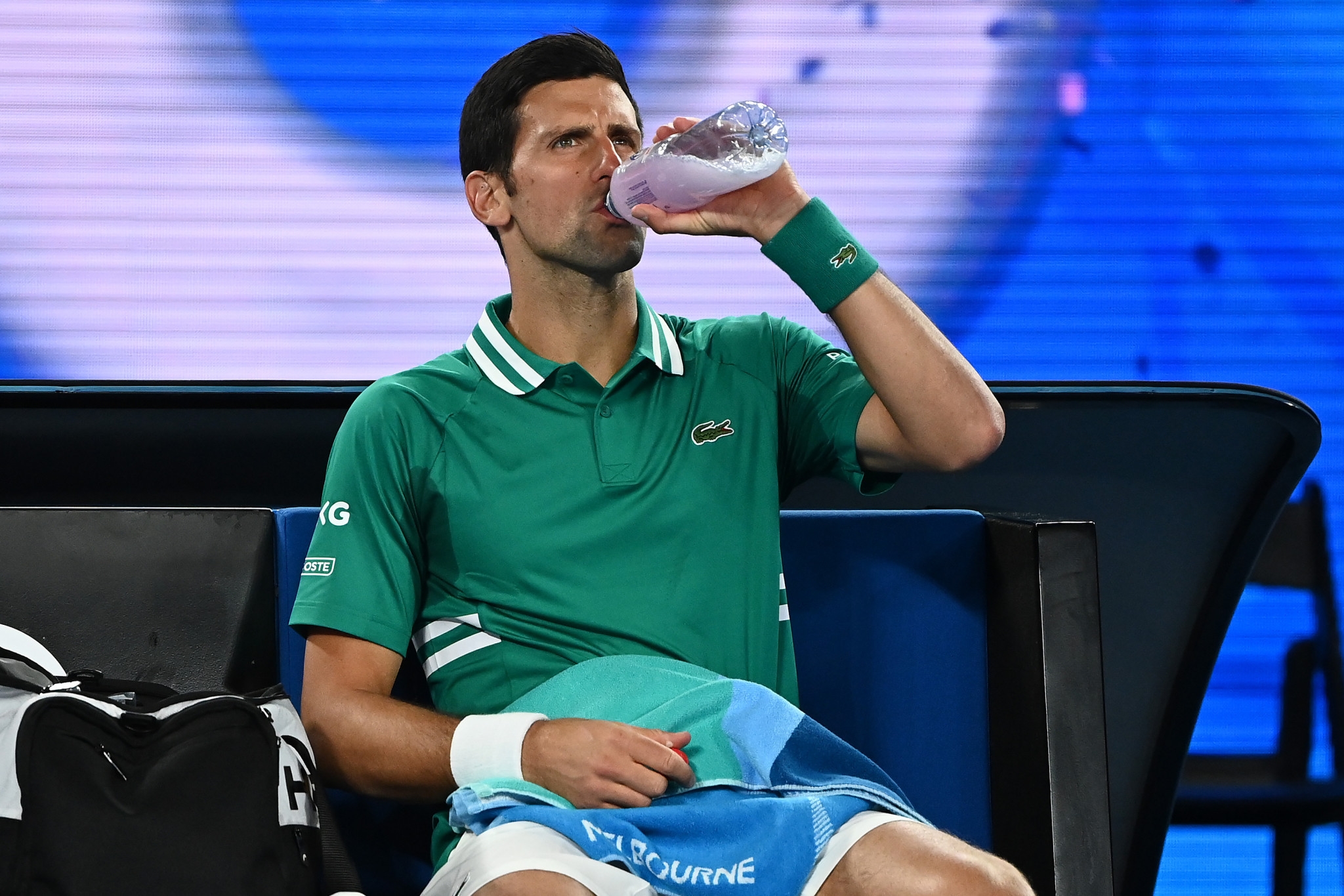 Defending men's champion Novak Djokovic takes a drink during a change of ends on the way to a first round win over Jeremy Chardy ©Getty Images